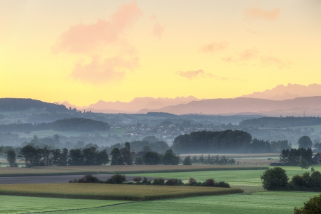 farmland with fog, mist and hills at sunrise, Switzerlandの写真素材