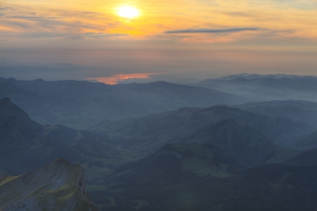 Aerial view on rolling green hills and in sunset mist with lake Bodensee in the distance, Switzerlandの写真素材