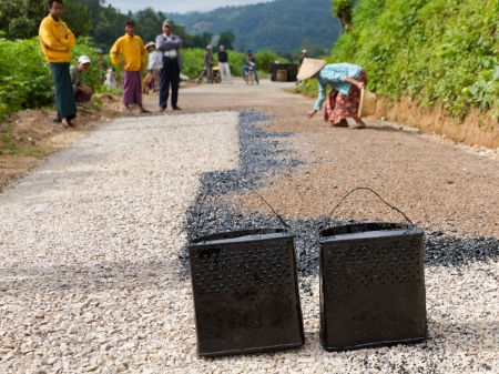 HPA AN, BURMA-OCT.  30: Workers build a black top tarmac road purely with manual labour on October 30, 2011 in Hpa An, Burma.  To keep costs low and provide jobs no machines are needed.のeditorial素材