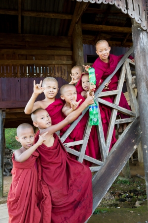 HPA AN, BURMA-OCT.  30: A group of young buddhist monk boys poses wearing maroon cowls at old monastery on October 30, 2011 in Hpa An, Burma.  のeditorial素材