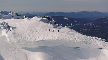 Mountaineers walking on snowy mountain ridge