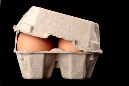 Eggs in paper box isolated on black backgroundの写真素材