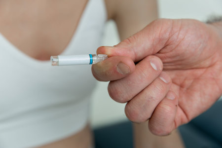 Doctor holds in hands small ampoules. Close up of small ampoule with a vaccine in the doctor hand....