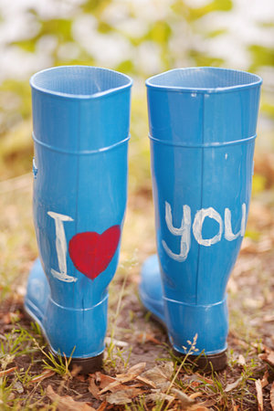 Blue rubber boots with the inscription I love you stand in the forest on the grass. Concept or...