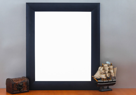 Empty Modern Blue Frame On Wooden Shelf With Vintage Box and Small Boat Modelの写真素材