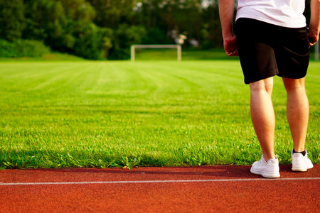 a man is standing in front of a soccer fieldの写真素材