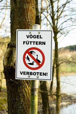 Hof, Germany - 04.25.2021: Notice sign "Feeding birds forbidden!" Translation: Do not feed the birds!のeditorial素材