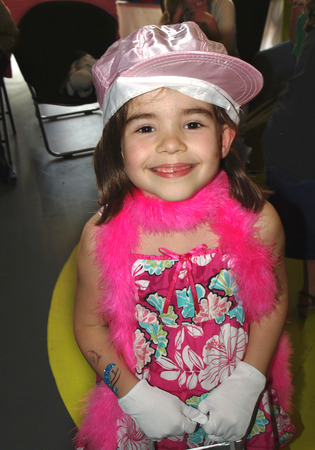 Smiling young girl looking at viewer playing dressupの写真素材