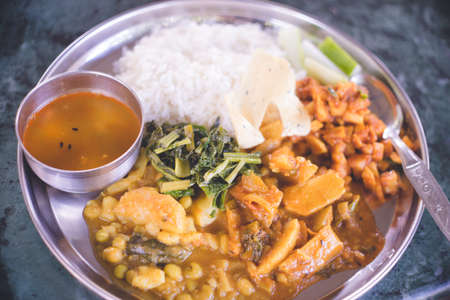 All-you-can-eat set meal of typical Nepali home cooking, "Dal bhat" which includes curry, vegetables and other side dishes, and pickles.の写真素材