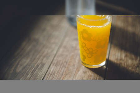 Orange juice in a cute retro glass cup on the porch of an old houseの写真素材
