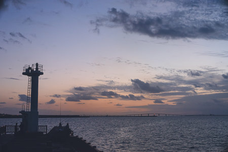 View of the Irabu Bridge and the sunset sea in the distance from a fishing port on the remote island of Miyakojima in Okinawa Prefectureの写真素材