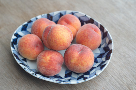 Fresh and beautiful plums on a plate on the tableの写真素材