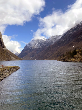 Mountain landscape with lake and snow-capped peaks in the background. Fjords of Norwayの写真素材