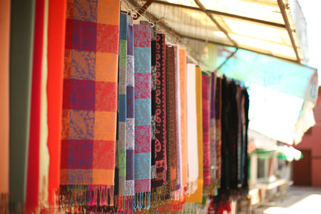 Colorful scarfs on hangers in a row, shallow depth of field
