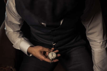 Close-up of a man's hands holding a pocket watch.の写真素材