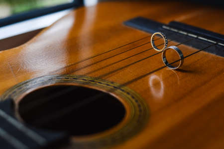 Wedding rings on acoustic guitar, close-up. Wedding and love conceptの写真素材