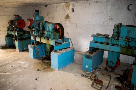 Three old elevator motors in a concrete lift room