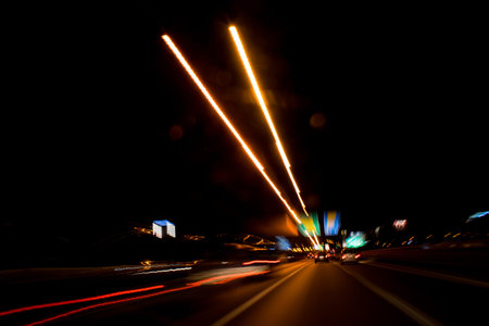 Night traffic lights on the road in the city. Long exposure. Driving Around Town. Light Rain. A view...
