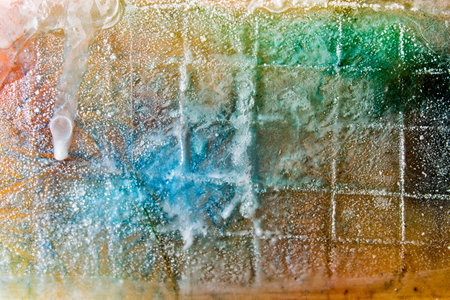 Ice plate melting. Multicolor. Abstract background for design. Colors trapped inside ice, flowing as ice melts.の写真素材