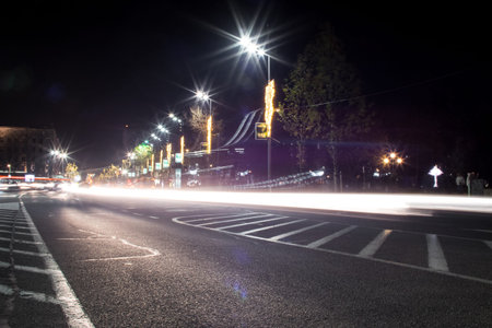 Night traffic in the city, light trails on the road, long exposure. Junction square. Cars passing....