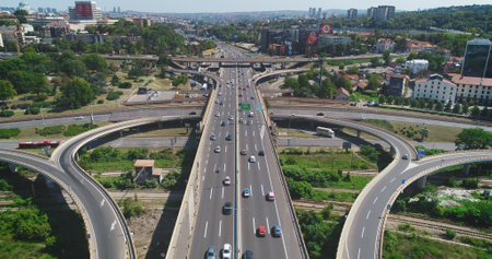 Aerial view of the highway. Traffic intersection. Road, cars, trucks. Camera high above the road. Drone shot of main highway traffic interchange.の写真素材