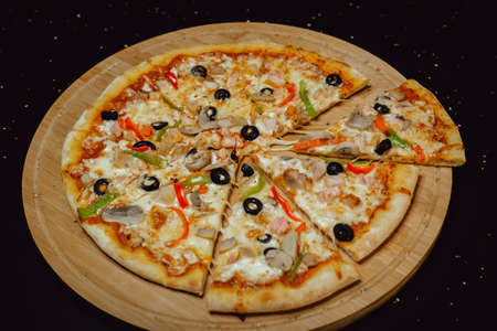 Delicious fresh pizza served on wooden plate. Pizza with olives.の写真素材