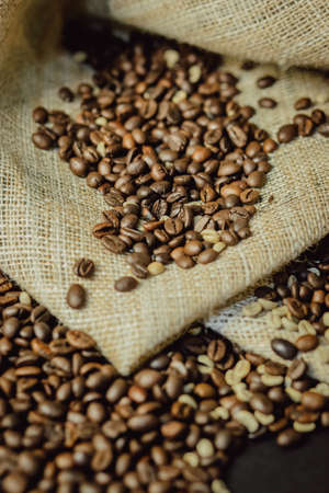 Roasted and green coffee beans on burlap closeup. Coffee beans background.の写真素材