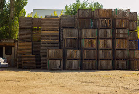 many empty wooden crates stacked on top of each other for storage, warehouse packaging for vegetables outdoors, farming, harvesting, packaging wooden boxesの写真素材