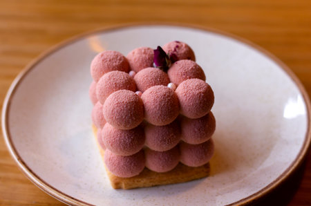 delicate Pink velours Moose cakes in the shape of a cube of balls decorated with a rose on a saucer...