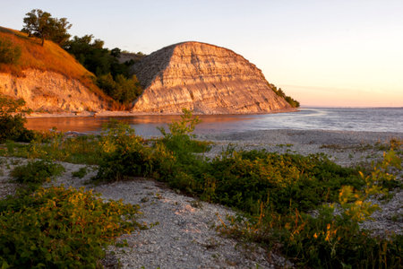 Dawn on the Volga. Beautiful cliffs by the river in the morning rays of the rising sun at golden...