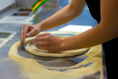 rolling out pizza bases from dough with pizza hands in a restaurant close-up