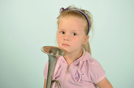 nice young girl with trumpet on blue background