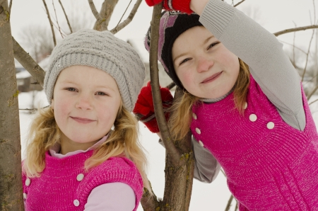 Young nice girls in winter among branches of treeの写真素材