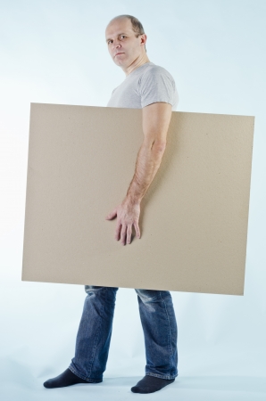 portrait of man holding empty table to put words on blue backgroundの写真素材