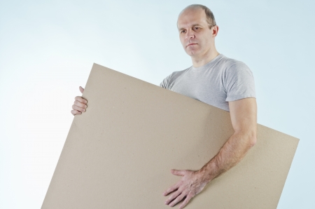 portrait of man holding empty table to put words on blue backgroundの写真素材