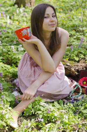 beautiful smiling  girl is holding red ornamented cupの写真素材