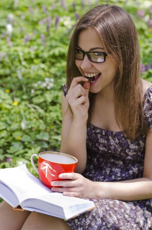 smiling beautiful girl in glasses is eating strawberryの写真素材