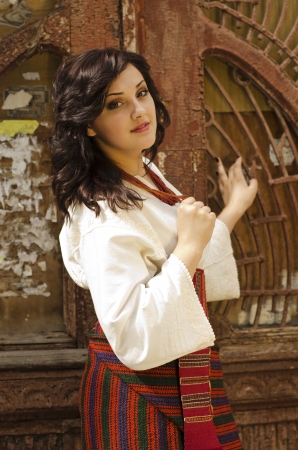 Portrait of beautiful young girl in traditional ukrainian cloth on old wood door backgroundの写真素材