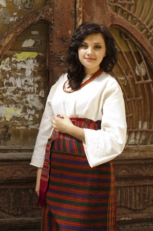 Portrait of beautiful young girl in traditional ukrainian cloth on old wood door backgroundの写真素材