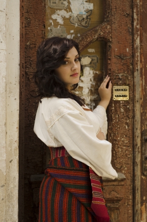 Portrait of beautiful young girl in traditional ukrainian cloth on old wood door backgroundの写真素材
