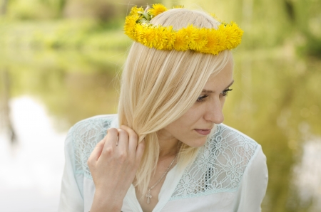 Portrait of beautiful blonde girl with wreath of dandelionの写真素材