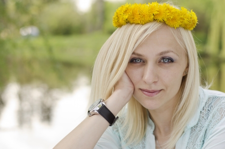 Portrait of beautiful blonde girl with wreath of dandelionの写真素材