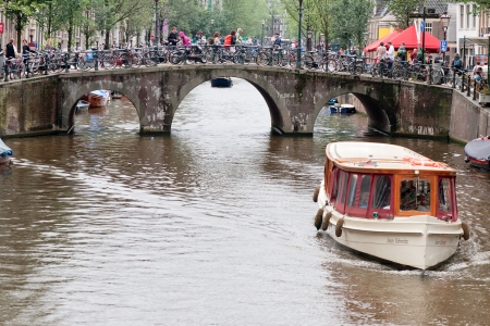 AMSTERDAM - JULY 17  Pleasure boat moves through the channel in the heart of Amsterdam, July 17, 2011のeditorial素材