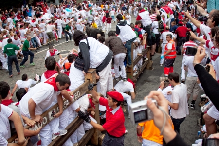 PAMPLONA, SPAIN -JULY 9: Unidentified men run from the bulls in the street Estafeta during the San Fermin festival in Pamplona, Spain on July 9, 2011.のeditorial素材