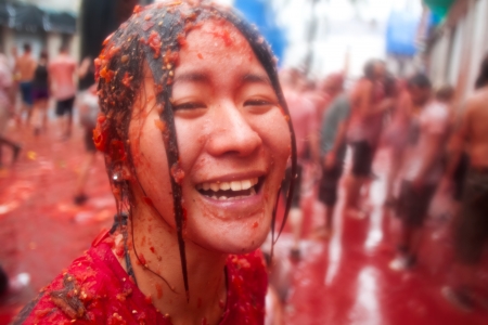 Bunol, Spain - August 28: The girl in crushed tomatoes laughs on Tomatina festival in Bunol, August 28, 2013 in Spainのeditorial素材