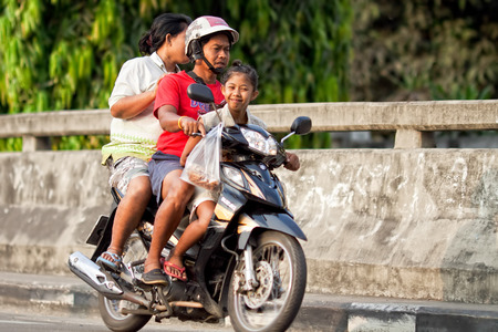 BANGKOK - FEBRUARY 28: Mom and Dad with a child riding on a motorcycle in Bangkok Thailand, February 28, 2014. A common way of move the local people in Thailand.のeditorial素材