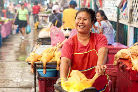 BANGKOK - DECEMBER 19: Saleswoman singe chickens on fire on largest market Khlong Toey in Bangkok, on street Rama IV, December 19 , 2013 A common way of earning a living amongst the local people in Thailand.のeditorial素材