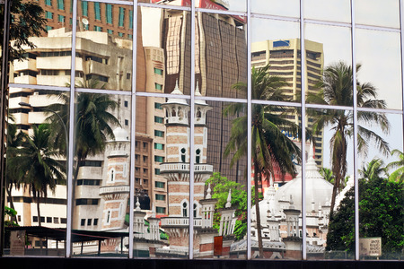 Mosque Jamek is reflected in windows of a skyscraper. Kuala Lumpur, Malaysiaのeditorial素材