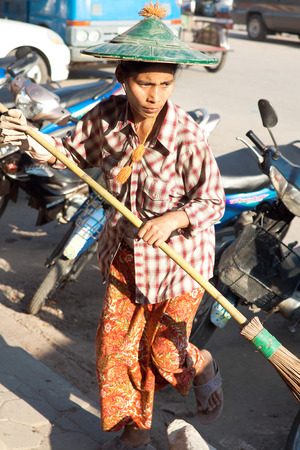 MYAWADDY, MYANMAR - FEBRUARY 2: Women janitor cleans streets before start of  holiday in Myawaddy, Karen State, Myanmar, February 2, 2014.のeditorial素材