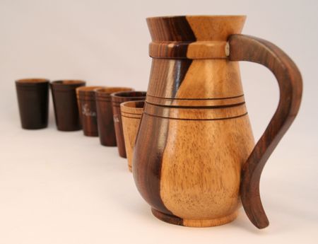 large wooden jug and cups in a rowの写真素材
